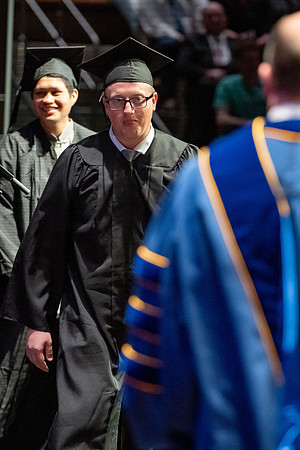 Graduates walk across the stage.