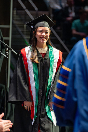 Graduates walk across the stage.