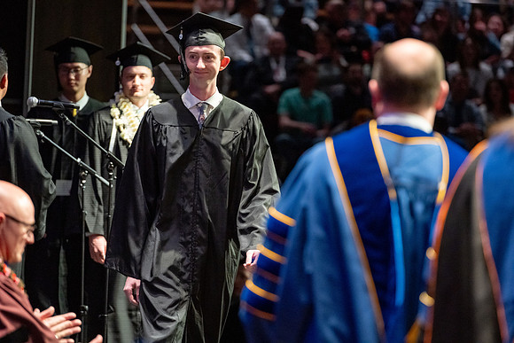 Graduates walk across the stage.