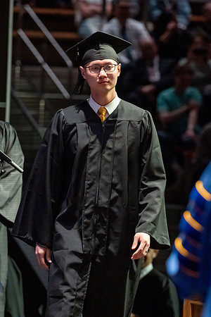 Graduates walk across the stage.