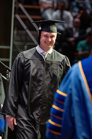 Graduates walk across the stage.