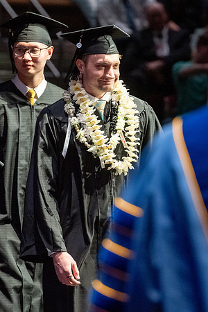 Graduates walk across the stage.