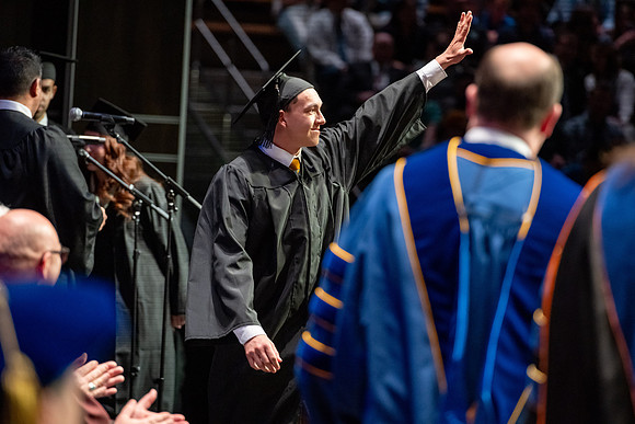 Graduates walk across the stage.