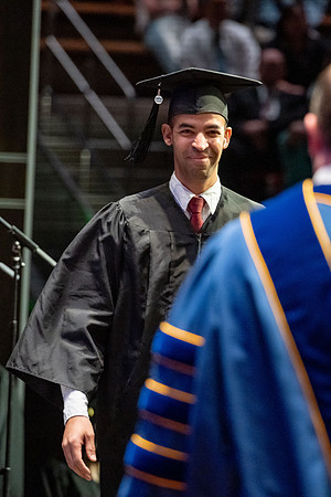 Graduates walk across the stage.