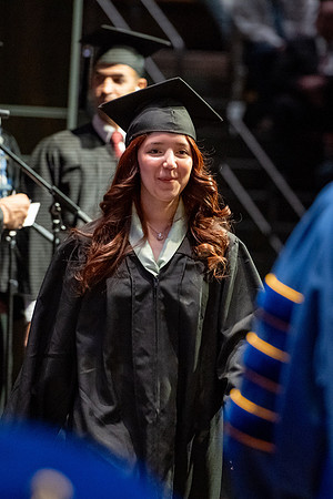 Graduates walk across the stage.