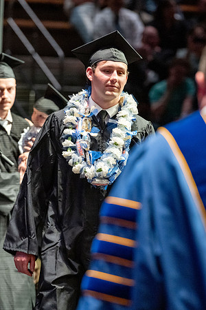Graduates walk across the stage.
