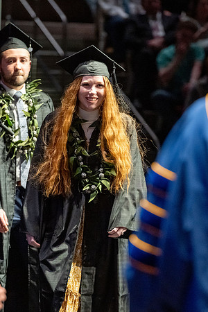 Graduates walk across the stage.