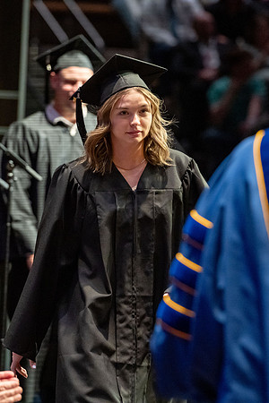 Graduates walk across the stage.