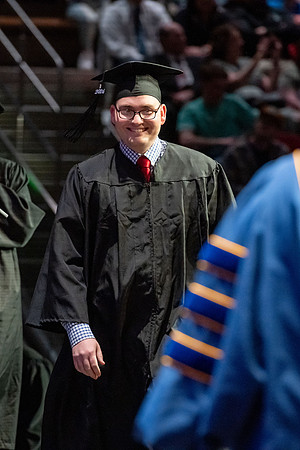 Graduates walk across the stage.