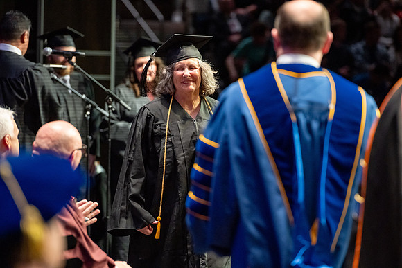 Graduates walk across the stage.