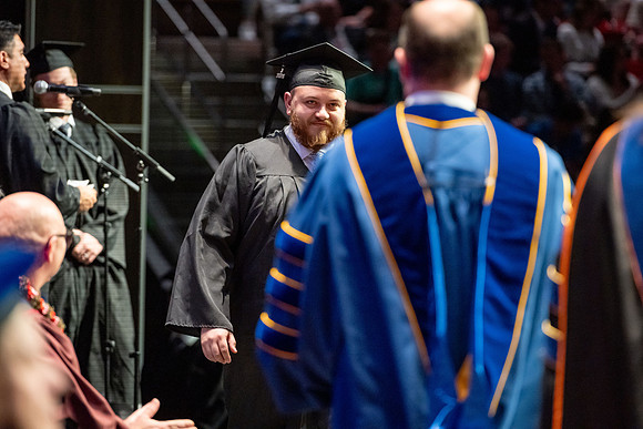 Graduates walk across the stage.
