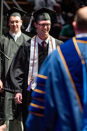 Graduates walk across the stage.
