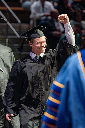Graduates walk across the stage.