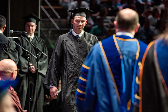 Graduates walk across the stage.