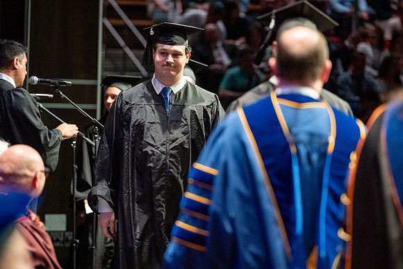 Graduates walk across the stage.