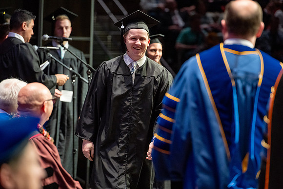 Graduates walk across the stage.