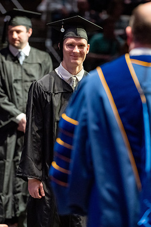 Graduates walk across the stage.