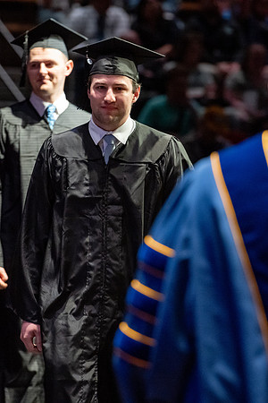 Graduates walk across the stage.
