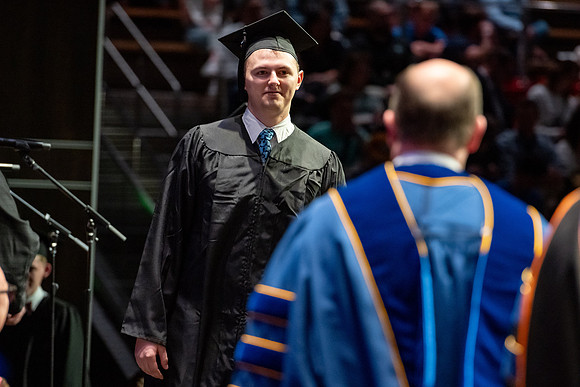 Graduates walk across the stage.