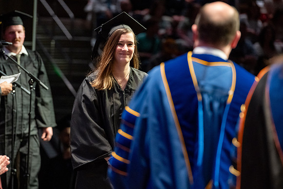 Graduates walk across the stage.