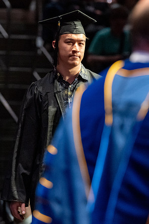 Graduates walk across the stage.