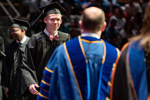 Graduates walk across the stage.
