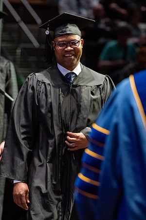 Graduates walk across the stage.