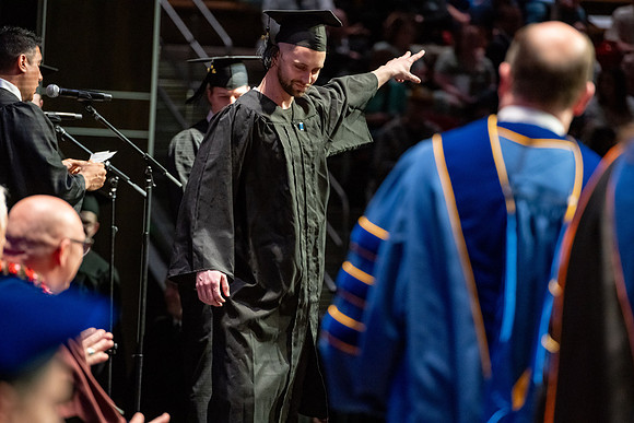 Graduates walk across the stage.