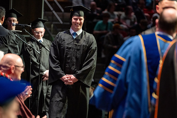 Graduates walk across the stage.