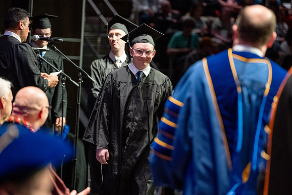 Graduates walk across the stage.