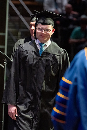 Graduates walk across the stage.
