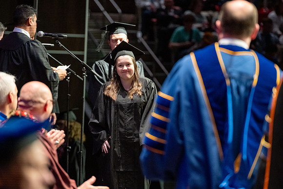 Graduates walk across the stage.