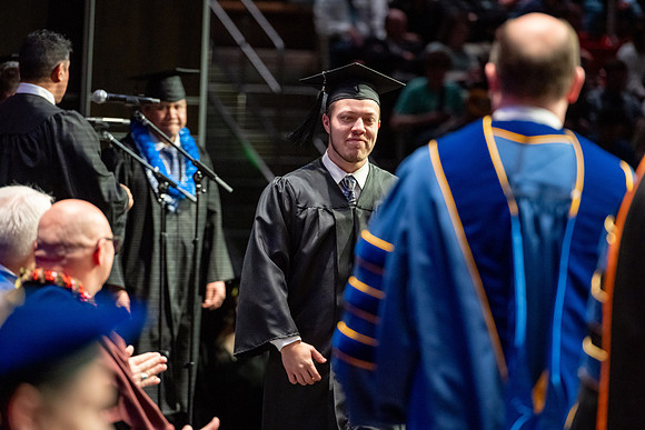 Graduates walk across the stage.