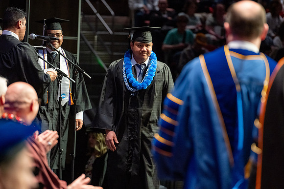 Graduates walk across the stage.