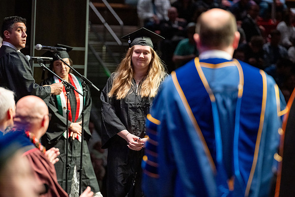 Graduates walk across the stage.