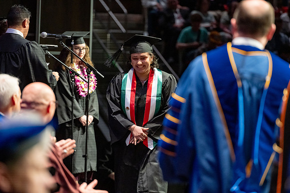 Graduates walk across the stage.
