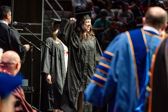 Graduates walk across the stage.