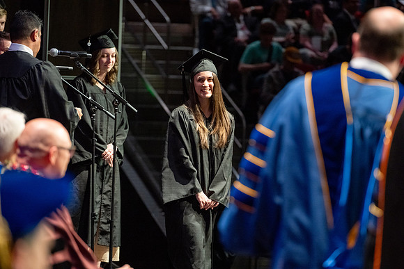 Graduates walk across the stage.