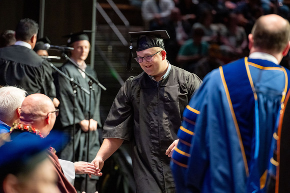 Graduates walk across the stage.