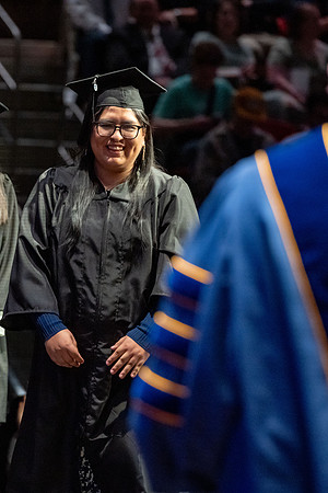 Graduates walk across the stage.