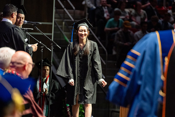 Graduates walk across the stage.