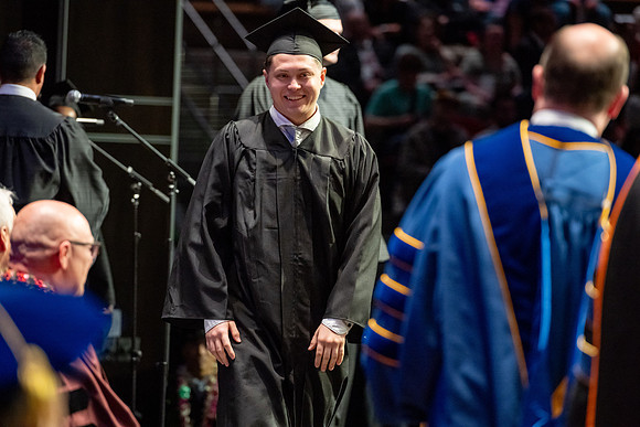 Graduates walk across the stage.