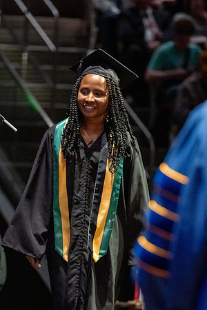 Graduates walk across the stage.