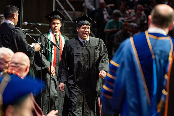 Graduates walk across the stage.