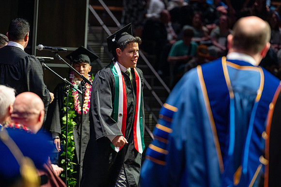 Graduates walk across the stage.