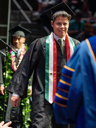 Graduates walk across the stage.