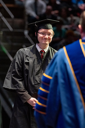 Graduates walk across the stage.