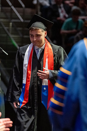 Graduates walk across the stage.
