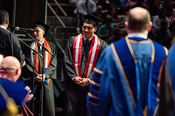 Graduates walk across the stage.