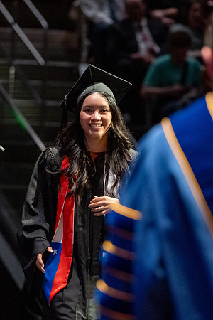 Graduates walk across the stage.